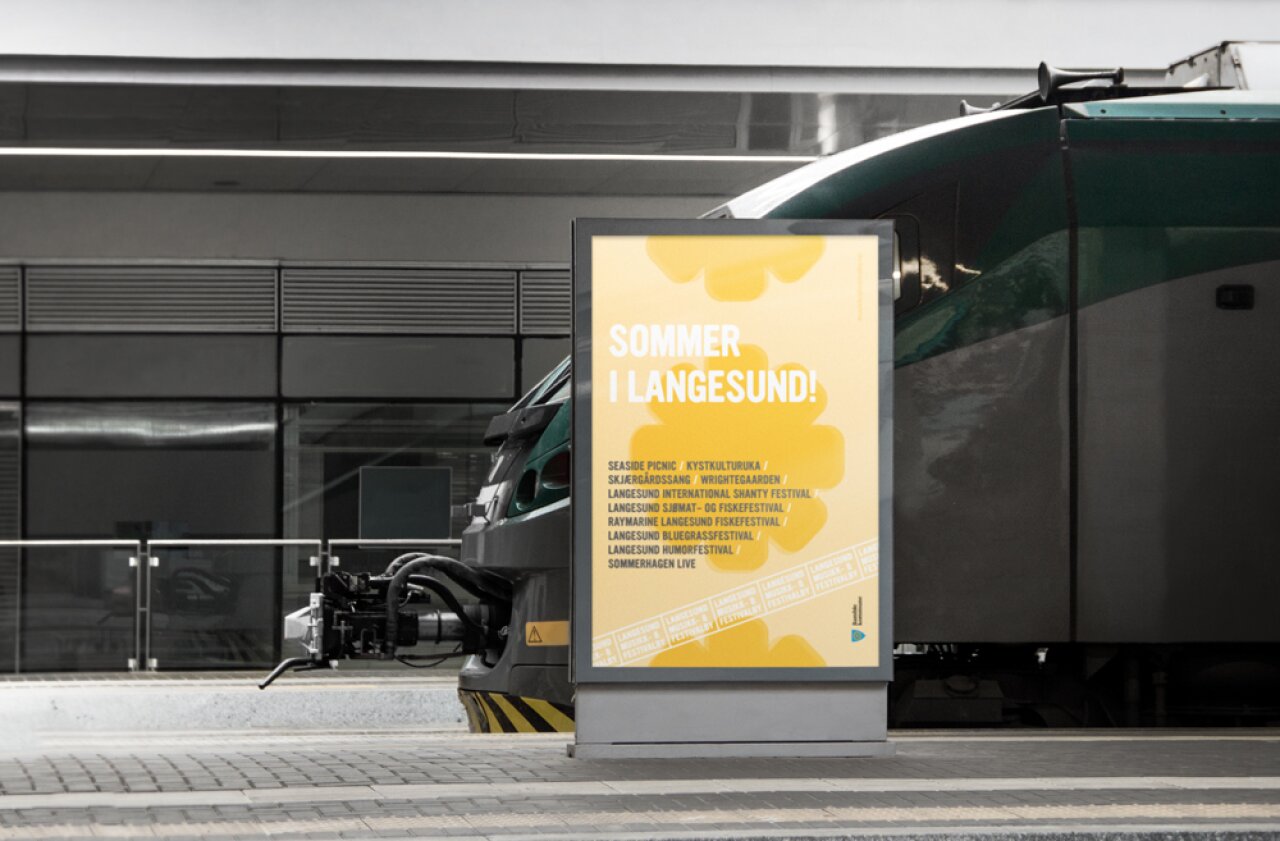 Sommer i Langesund, gul plakat på togstasjon