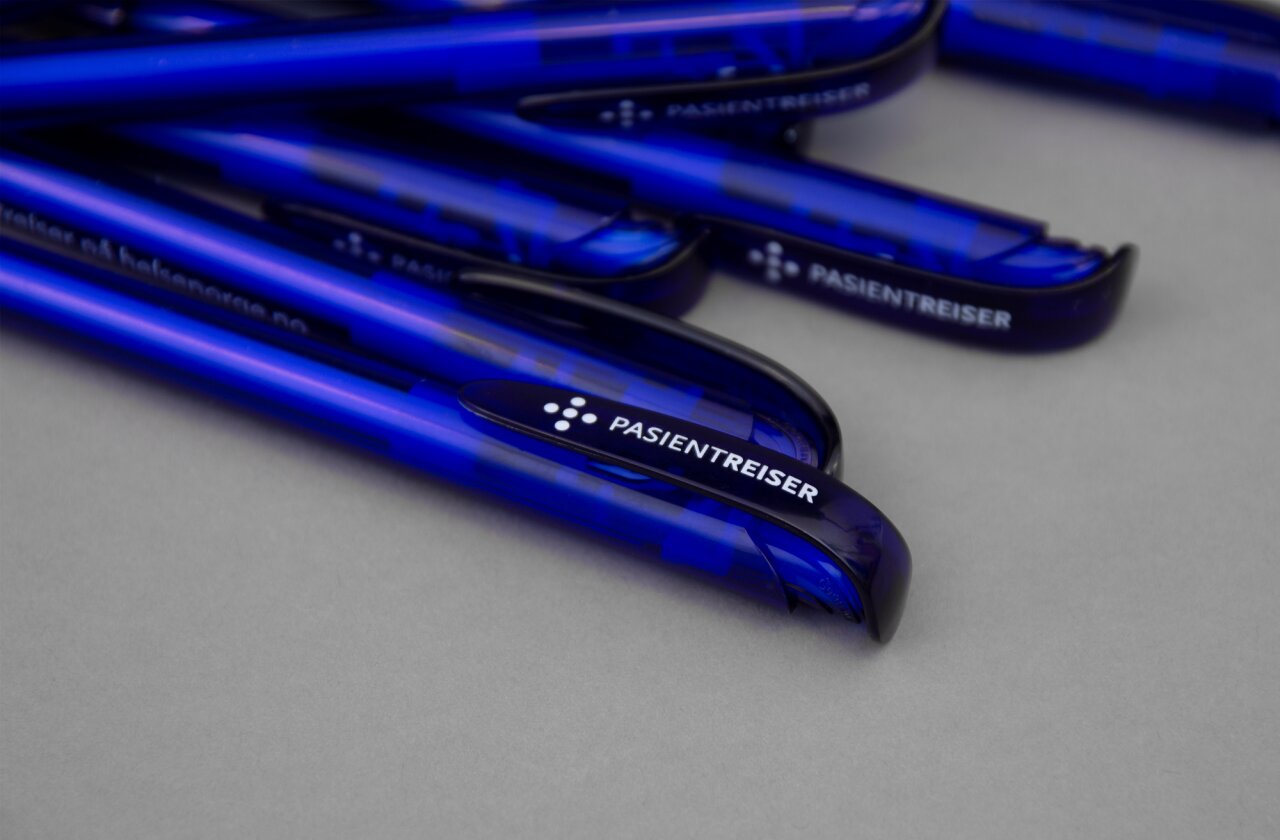 Bunke med mørkeblå penner med logoen til Pasientreiser